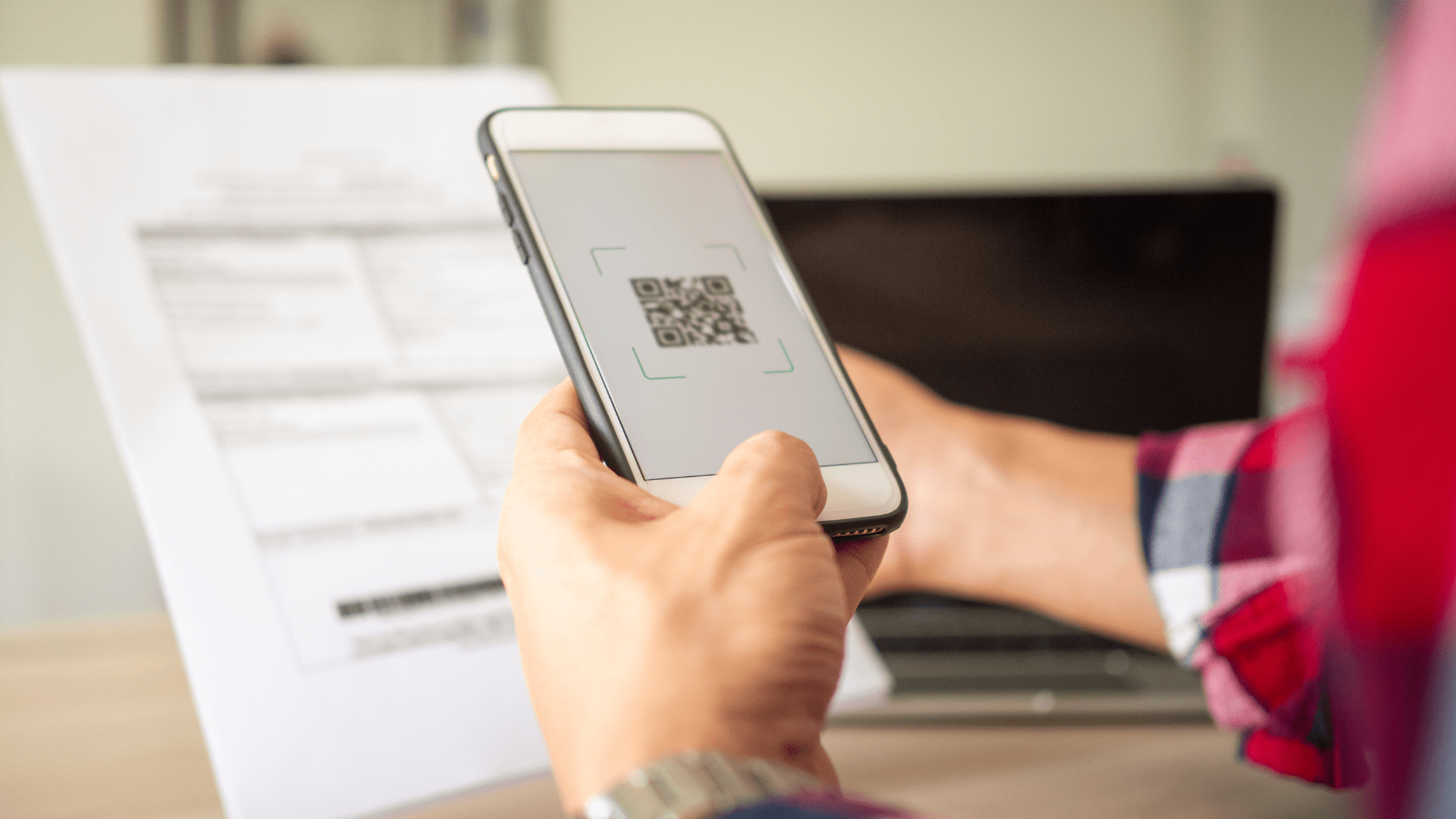 A person scanning a QR code on a letter